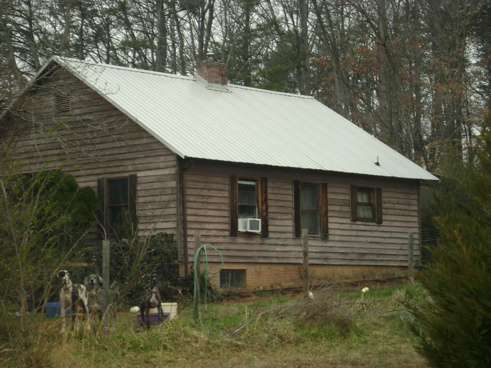 White metal roof on an old wood sided farmhouse, from a Metal Roof Installation job in Ontario